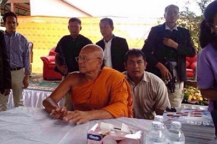 A widely-shared photo of Suthep Thaugsuban sitting in front of two armed men.<br />