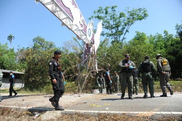 Security officers inspect site of a roadside bomb attack in Narathiwat province, 4 April 2015<br />