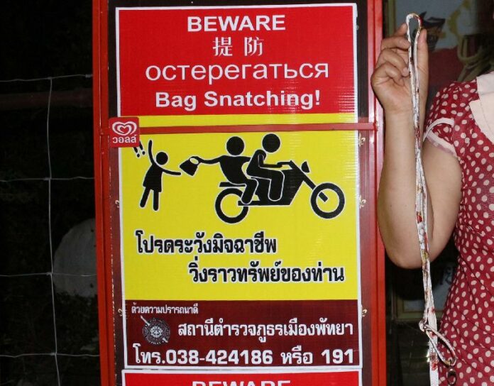A police warning sign about bag snatchers in Pattaya, Chonburi province.