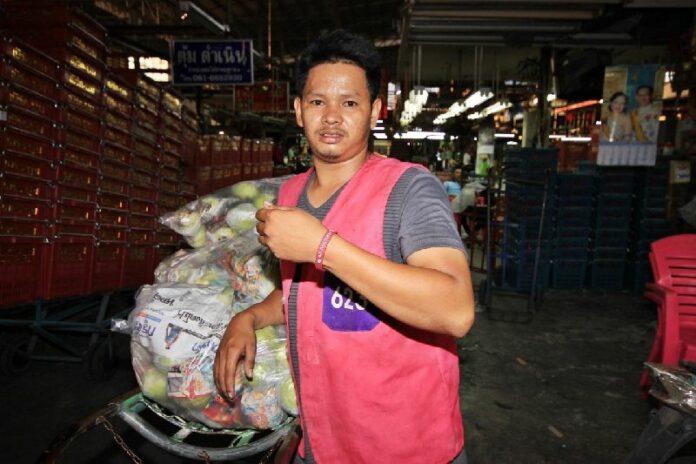 A foreign worker showing his registered bracelet at Talaad Tai in Pathum Thani, 22 April 2015.<br />