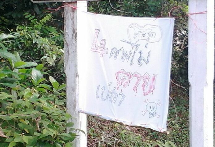 A sign hung by the entrace of To Chud village, found by police on 24 April 2015.<br />