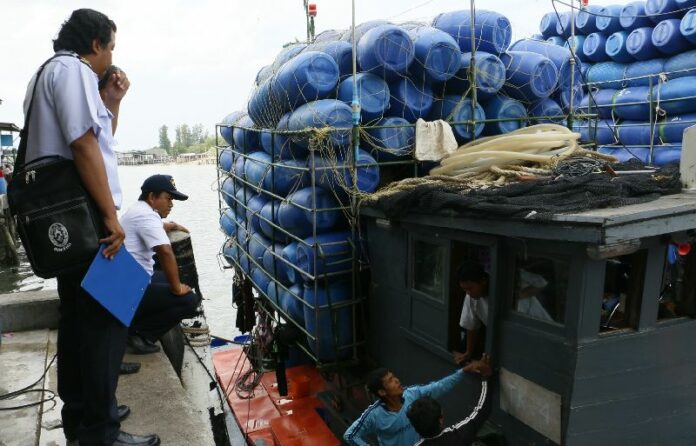 Officials investigate workers at Saphan Pla pier in Ranong province, 27 April 2015.<br />