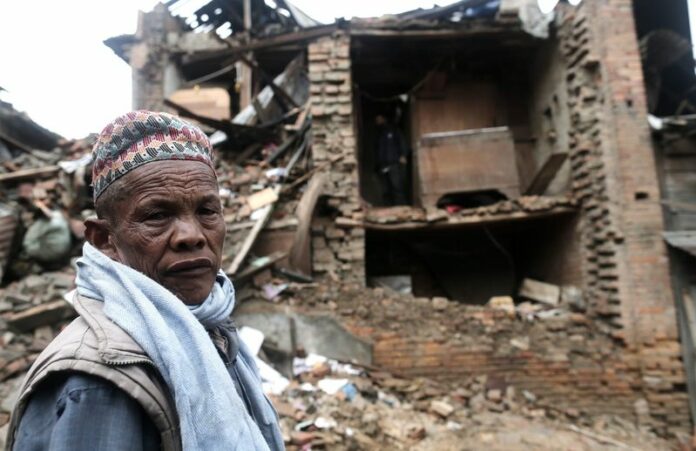 A man stands in front of a home in Bhaktabur destroyed in the Nepal earthquake over the weekend. EPA/SEDAT SUNA<br />