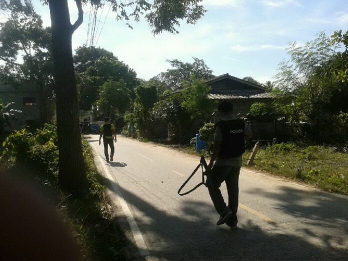 Police officers at the crime scene in Pattani province where a suspected terrorist was shot and killed, 2 May 2015.<br />