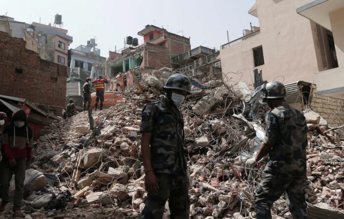 Nepalese soldiers and members of a search and rescue team work on removing debris from a destroyed building in Kathmandu. EPA/SEDAT SUNA<br />