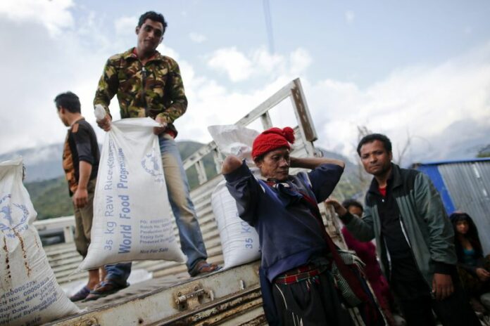 Nepali villagers offload sacks of food donated by the World Food Program (WFP) in Baluwa, a village in the Nepalese district of Gorkha. Villagers have had to start distributing emergency provisions by themselves in many places because official aid has yet to reach many of the survivors. EPA/DIEGO AZUBEL<br />
