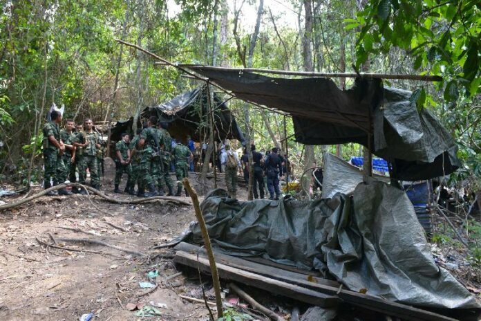Officers inspect the suspected Rohingya migrant detention camp May 1, 2015 in Songkhla province.