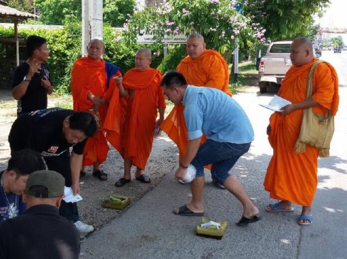 Buddhist monks pray over the spot where 3 cyclists were killed in Chiang Mai on 3 May 2015.