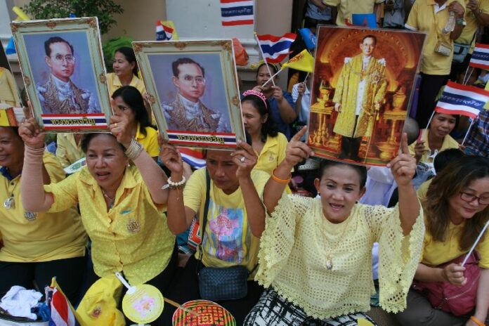 Bangkokians line the street in celebration as King Bhumibol's motorcade leaves Siriaj Hospital, 10 May 2015.<br />