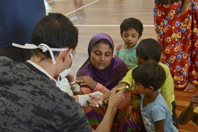 A Malaysian official marks an Rohinghya migrant in Kuah, on Langkawi island. More than 8,000 migrants were adrift off the coasts of Thailand, Malaysia and Indonesia, an IOM official said Tuesday, posing a potential humanitarian crisis for the region's governments. EPA/STR<br />