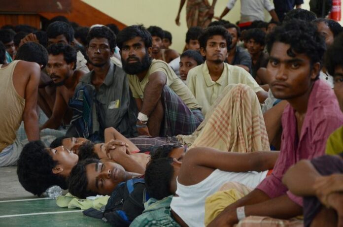 Migrants from Myanmar and Bangladesh sit at a police station in Kuah, Langkawi. In Malaysia 1,018 migrants were found in two operations Sunday on the island of Langkawi, about 400 kilometres north of Kuala Lumpur. EPA/STR<br />