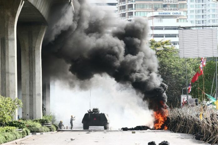 Soldiers storming the Redshirts' encampment in Bangkok's financial district on 19 May 2010.<br />