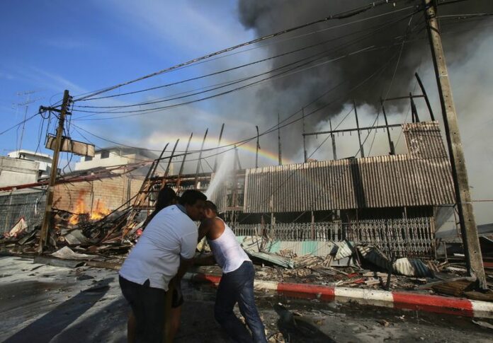 Thai firemen and volunteers try to extinguish a fire after a bomb attack in Yala, southern Thailand, 06 April 2014. Up to 39 explosions injured 22 people over the past three days in Thailand's restive southern province of Yala. EPA/NAKHARIN CHINNAWORNKOMOL<br />