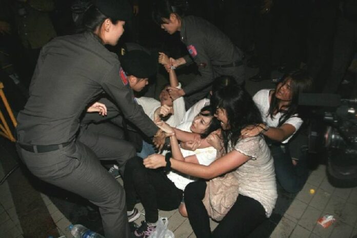 Police drag a student activist away from an anti-coup protest in front of the BACC in Bangkok on 22 May 2015.<br />
