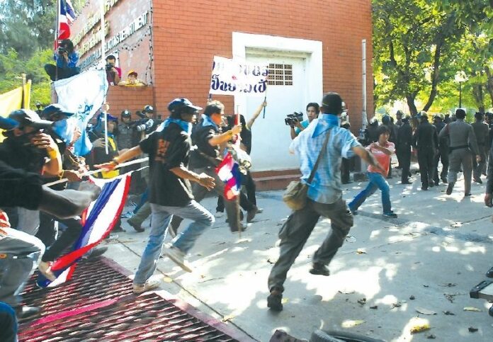 Yellowshirt protesters rush into the state-owned Channel 11 in Bangkok after tearing down the gate, 26 August 2008.