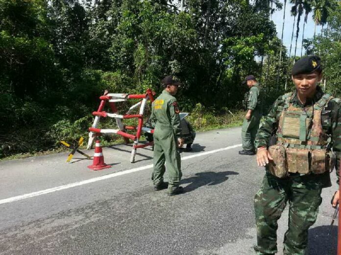 Soldiers inspect the checkpoint in Narathiwat where suspected insurgents and soldiers exchanged gunfire on 24 May 2015.