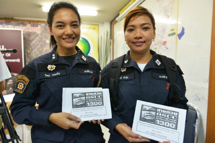 Police officers in Songkhla province with signs that encourage locals to call an anti-trafficking hotline if they have any knowledge of human trafficking, 11 May 2015<br />