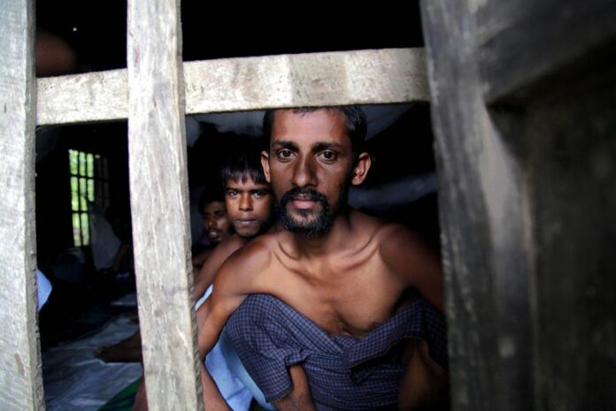 Rohingya Muslims from Bangladesh rescued by the Myanmar navy sit inside buildings at a temporary refugee camp in the village of Aletankyaw in the Maungdaw township of northern Rakhine state. EPA/NYUNT WIN<br />