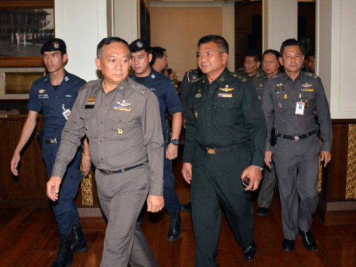 Lt.Gen. Manas Kongpaen (in green) surrendered to police at the at the Royal Thai Police HQ in Bangkok on 3 June 2015.