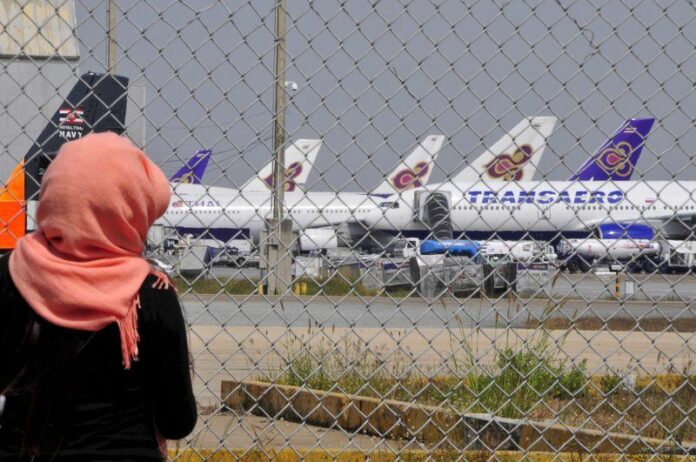 A file photo shows a foreign tourist looking through the security fence at the U-Tapao international airport near Pattaya, 30 November 2008. EPA/UDO WEITZ