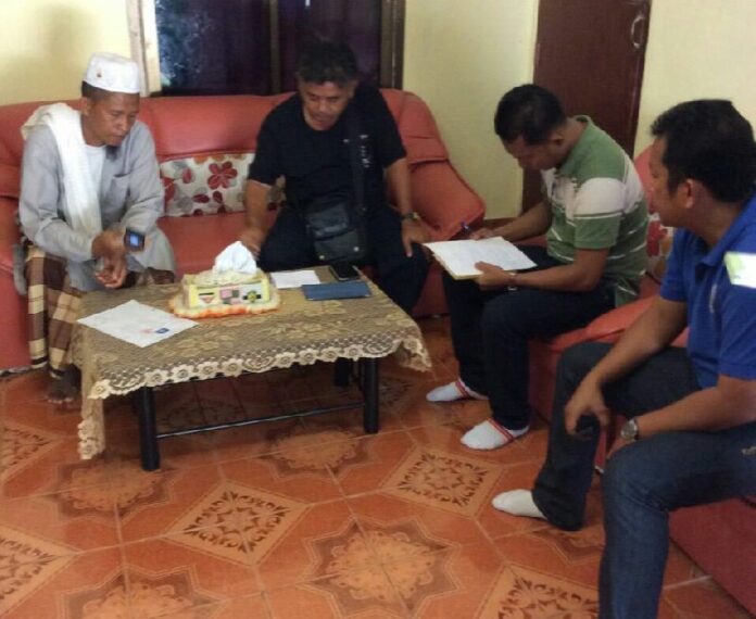 Prasert Suthok (L), father of Faruk Suthok, talks to police officers from Special Branch Police at his home in Krabi province, 11 June 2015