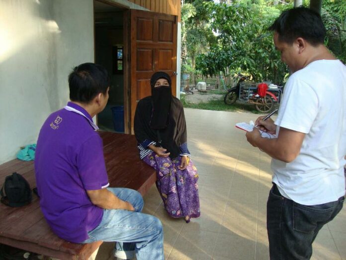 Reporters speaking to the mother of Abhisit Mhad-ad, one of five Thais arrested in Pakistan for attempting to bring a gun on board a plane, Songkhla, 12 June 2015.<br />