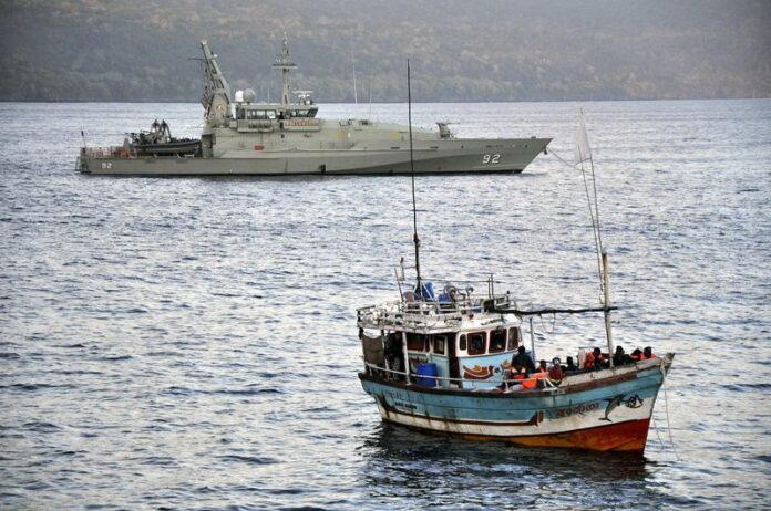 A file photo shows a boat full of asylum seekers escorted by Australian navy patrol boats being moored in Flying Fish Cove, Christmas Island, Australia, 16 August 2012. EPA/SCOTT FISHER