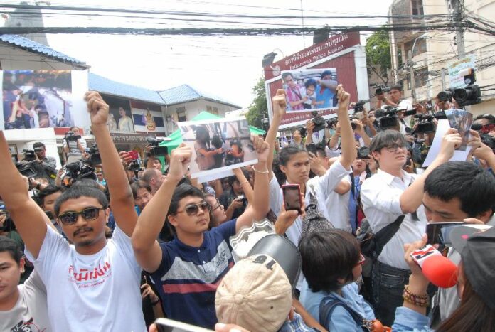 Student activists from Bangkok outside of Pathumwan Police Station with photographs of the security officers who cracked down on their anti-coup rally, 24 June 2015.<br />