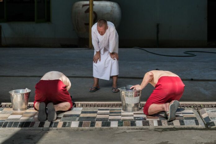 Two patients vomit after drinking an herbal potion at the Thamkrabok Monastery Drug Treatment and Rehabilitation Centre in Phra Phutthabat. DPA/IAN ROBERT KNIGHT<br />