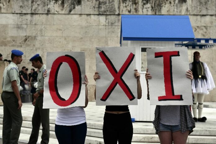 Greek leftist youth hold letters reading "No" in Greek during a demonstration calling for an exit from the eurozone and a "No" vote in the upcoming referendum in Athens on June 28, 2015. Greece weighed drastic banking restrictions to stave off a financial collapse as anxious Greeks emptied cash machines amid fears that banks will be closed this week. AFP PHOTO / LOUISA GOULIAMAKI