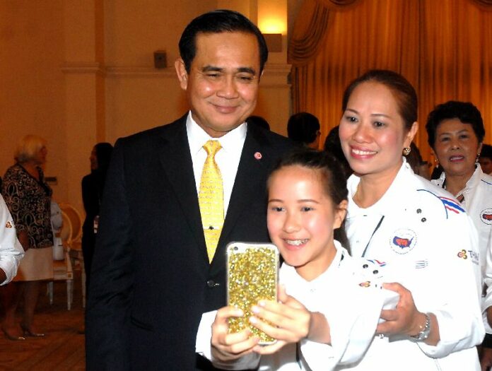 Thai junta leader Gen. Prayuth Chan-ocha takes a selfie with a young Thai girl raised in the US at the Government House in Bangkok on 8 July 2015.