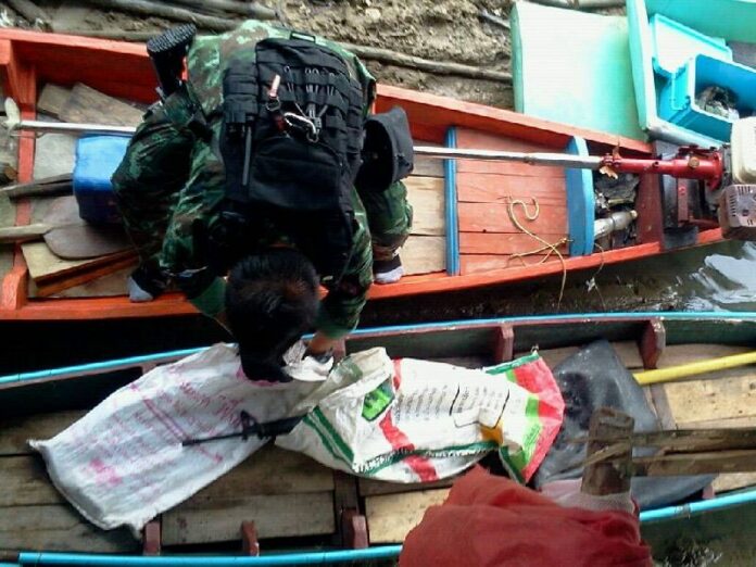 Soldiers inspect boats behind a house in Pattani raided by officers on 20 July 2015.