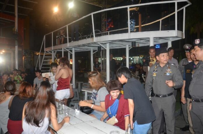 Police raid a bar in Pathum Thani that violated the junta's new booze ban by selling alcohol within 300 meters of a university, 25 July 2015.
