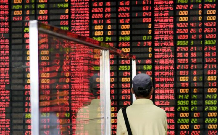An investor looks at screens showing stock market movements at a brokerage house in Shanghai on July 29, 2015. AFP PHOTO / JOHANNES EISELE