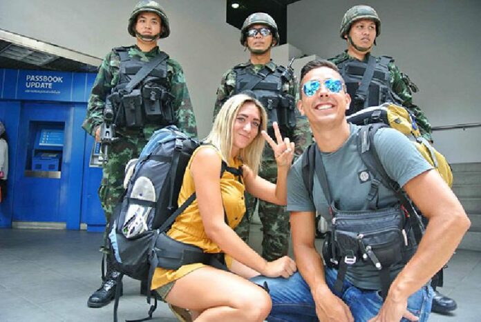 Foreign tourists pose with soldiers in Bangkok several hours after the military declared martial law nationwide on 20 May, 2014.