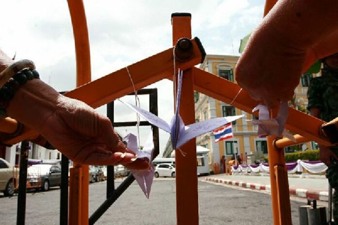 Pro-democracy activists hang cranes outside Bangkok's martial court on 7 July 2015.