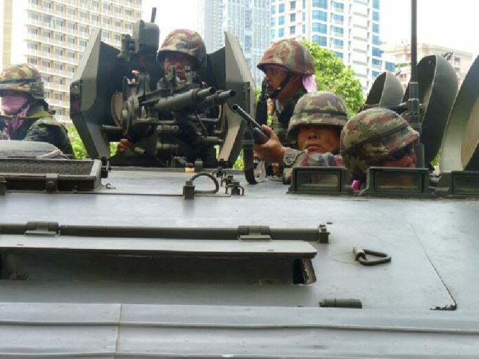 Soldiers perch atop an armored personnel carrier as it rolls into Lumpini Park on 19 May, 2010, where a fortified encampment had been erected by protesters. Photo: Todd Ruiz