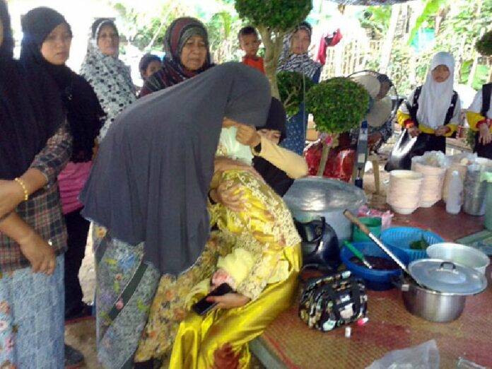 Family members console the bride of Army Ranger Ahmad Dao, 28, who was shot to death yesterday as he was welcoming guests to their wedding party in Pattani province.