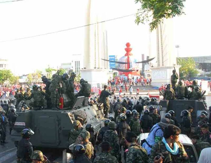 Soldiers watch over an anti-government demonstration by Redshirt protesters at Bangkok's Democracy Monument on 10 April, 2010.