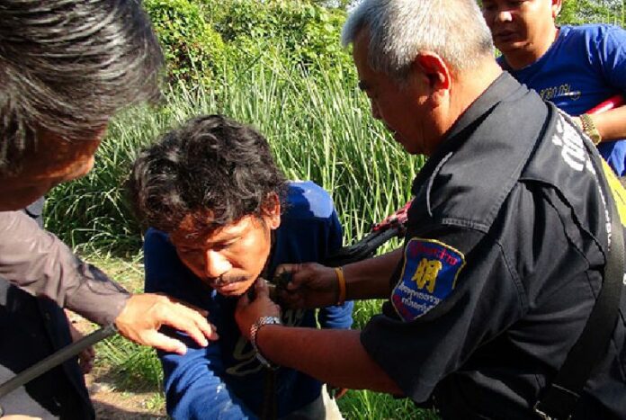 A rescue worker cuts a chain tethering Pichai Angpasi's moto to his neck he said was put there by a couple early this morning he had stopped to lend aid to on a road in Prachinburi province. He later confessed to making it all up.