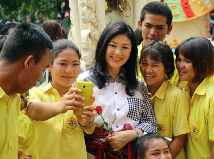 Former Prime Minister Yingluck Shinawatra poses with students at a temple in Sisaket province on 7 July. Photo: Facebook