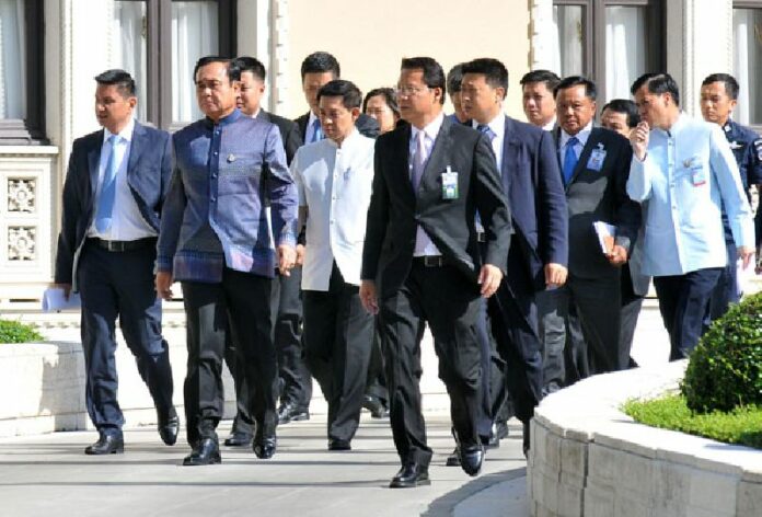 Prime Minister Gen. Prayuth Chan-ocha walks near Government House yesterday with some of his ministers.