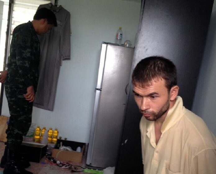 A soldier searches the room of an unidentified foreign national Saturday in Bangkok's Nong Chok district.
