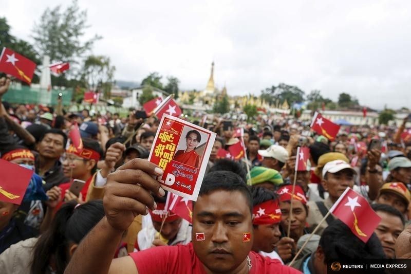 A man holds a sign as Myanmar pro-democracy leader Aung San Suu Kyi gives a speech about voter education Sunday in the Hopong township in Shan state.