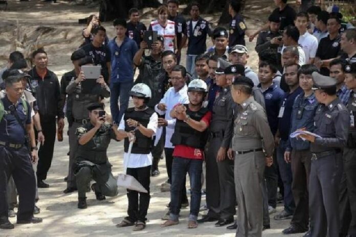 Wearing helmets and handcuffs, two Myanmar migrant laborers accused of killing two British tourists on Koh Tao in September 2014, participate in a 're-enactment' of the alleged crime in this 3 Oct., 2014, file photo. Photo: Reuters