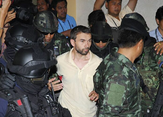 Mohammed Bilaturk, aka Adem Karadag, is transferred from military custody to civilian police at the Bangkok Metropolitan Police headquarters on 4 Sept.