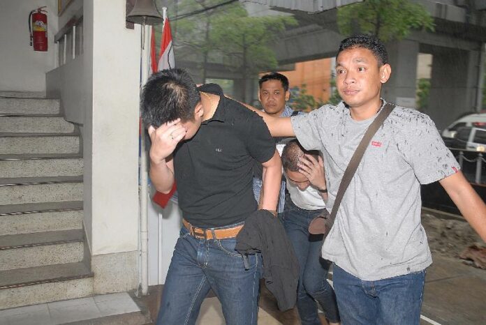 Police Lance Cpl. Boonseth Wutthiwinyuchon and associate Chutirat Thanormsingha, both 27, are questioned by police this morning at the Makkasan Police Station.