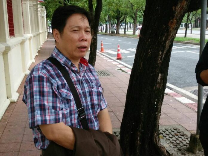Sakda Sae-Eiaw, a cartoonist for Thai Rath newspaper who uses the pen name 'Sia Thai Rath' speaks to reporters Sunday before reporting to military authorities at the Royal Thai Army headquarters in Bangkok.