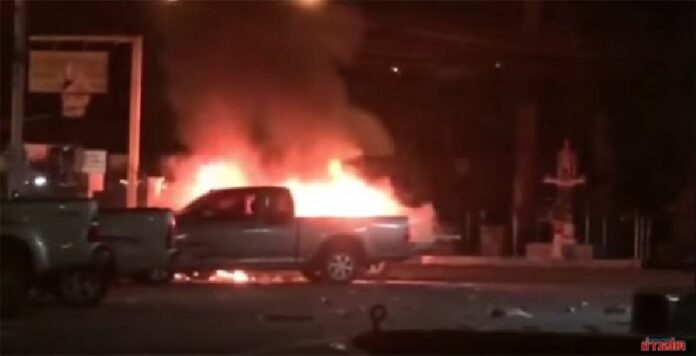 Vehicles burn outside the Thalang Police Station on Phuket early this morning.