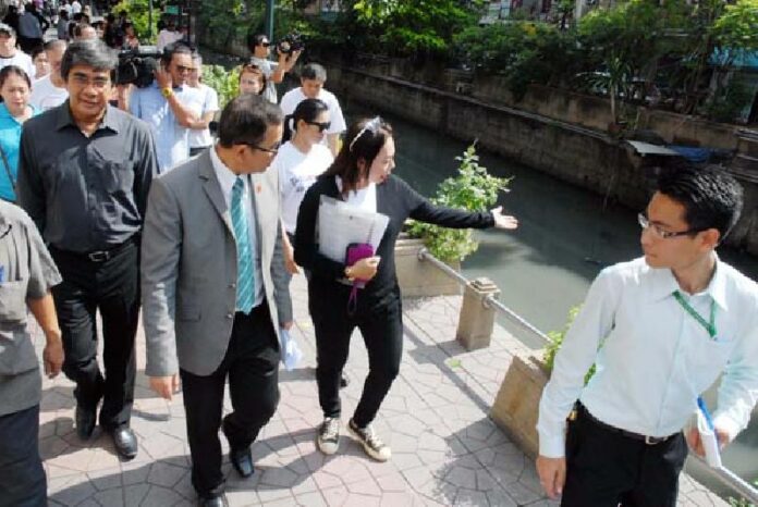 A Saphan Lek vendor, at center, gestures toward Khlong Ong Ang with Deputy Secretary General of the national Ombudsman’s office Thavin Injamnong, second from left, who visited Saphan Lek and the nearby area today for an inspection after vendors filed a complaint Friday with his office.